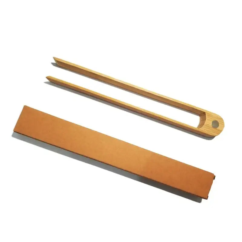 Light brown bamboo toaster tongs with smooth rounded ends and a natural finish for kitchen use
