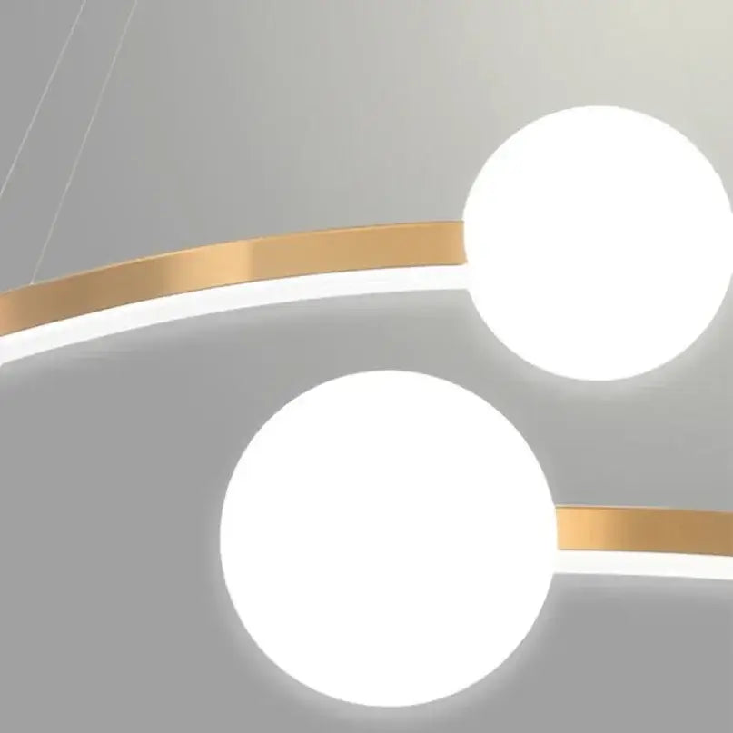 Modern glass pendant with two glowing white spheres connected by sleek gold-toned metallic bands decorbites gold nordic ring led chandelier