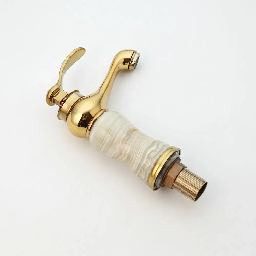 Gold plated jade bathroom faucet with a gold finish and translucent swirling white beige marble base hot cold mixer