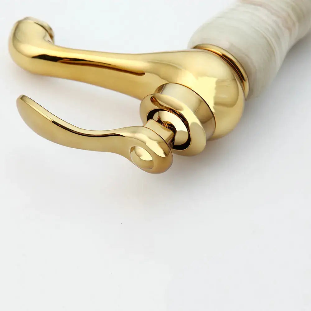 Gold plated jade bathroom faucet with polished curved spout handle and white marble-like base for hot cold mixer use