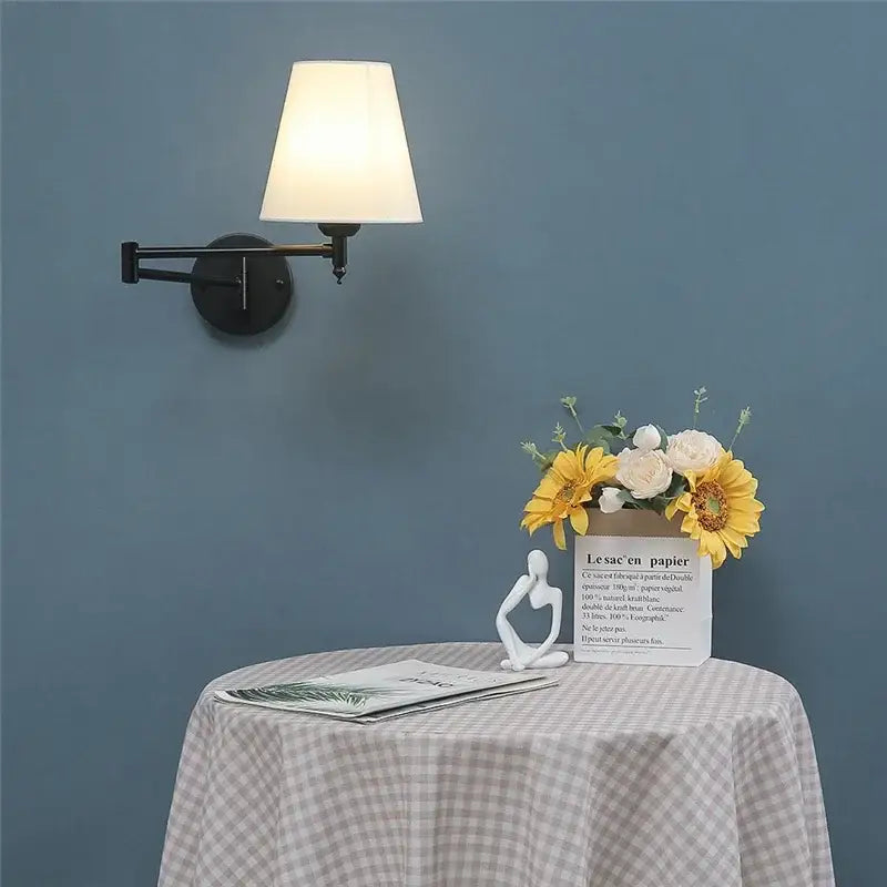 White paper bag vase with sunflowers and white roses complements gold pleated decorbites adjustable led wall lamp