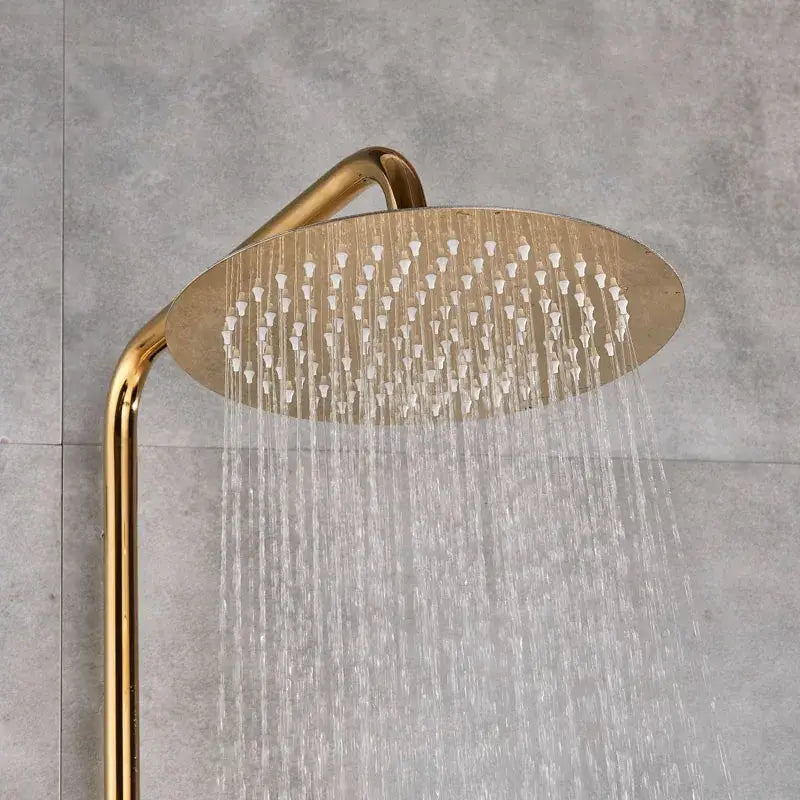 Gold-toned round showerhead with multiple water jets streaming downward in a shower faucet set bathroom system
