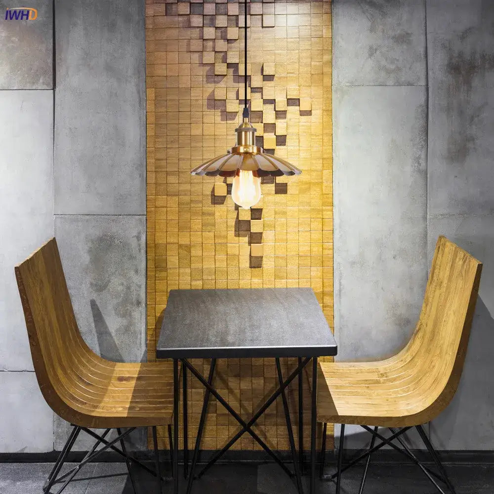 A warm-toned brass decorbites gold retro edison pendant light with a fluted petal shade above a dining table set