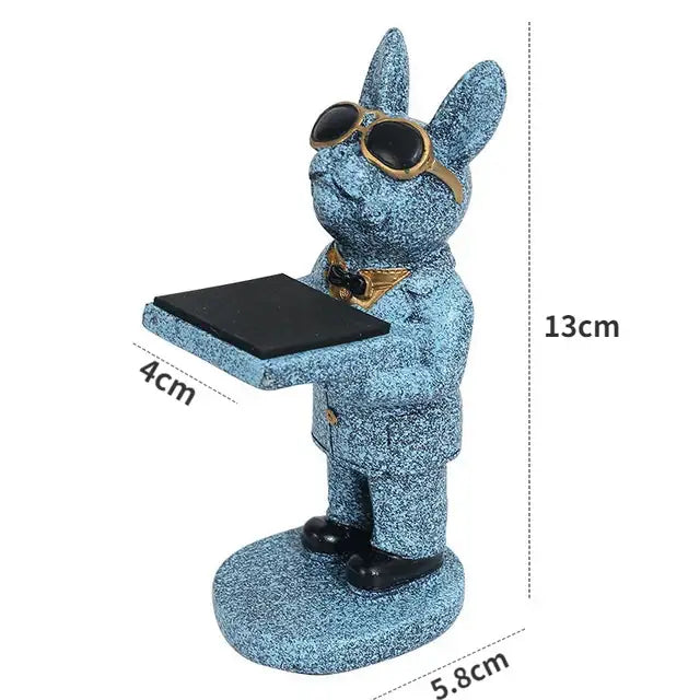 Blue glittery rabbit figurine wearing gold-rimmed sunglasses holding tray paired with gold and silver bear statue watch rack