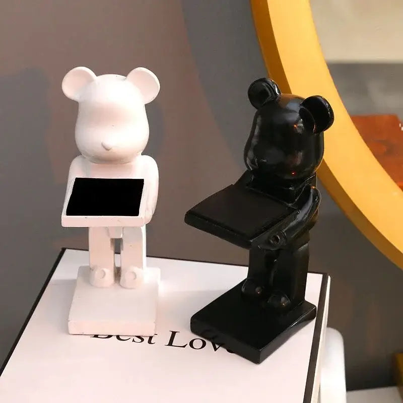 White and black glossy bear statue watch racks each holding a tablet display for bedroom storage stand use
