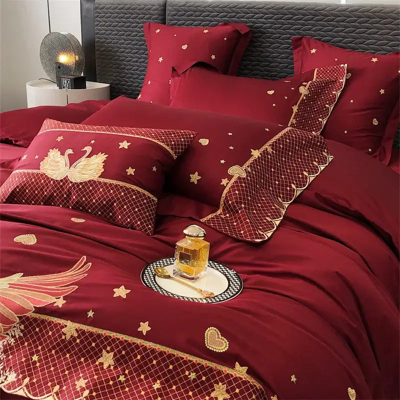 Deep red satin bedding set featuring gold swan love embroidery with swans stars and heart motifs by Decorbites gold swan