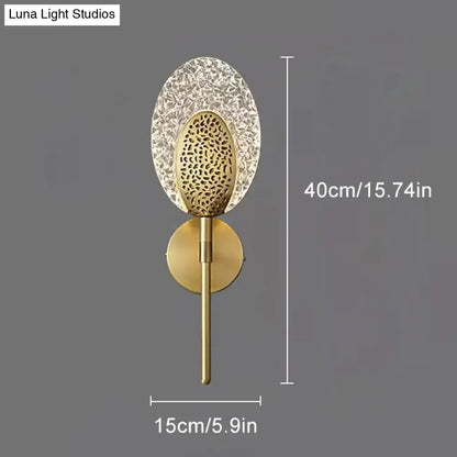 Gold-toned led wall lamp with textured glass crystal shade and perforated metal center for indoor lighting
