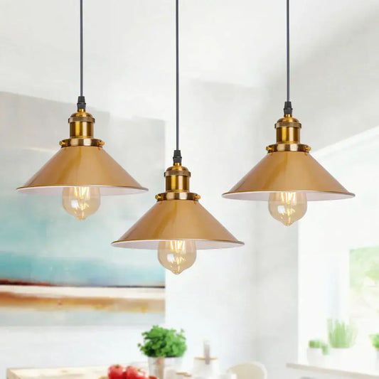 Three brass-finished gold vintage industrial pendant lamps with conical shades and exposed filament bulbs by decorbites