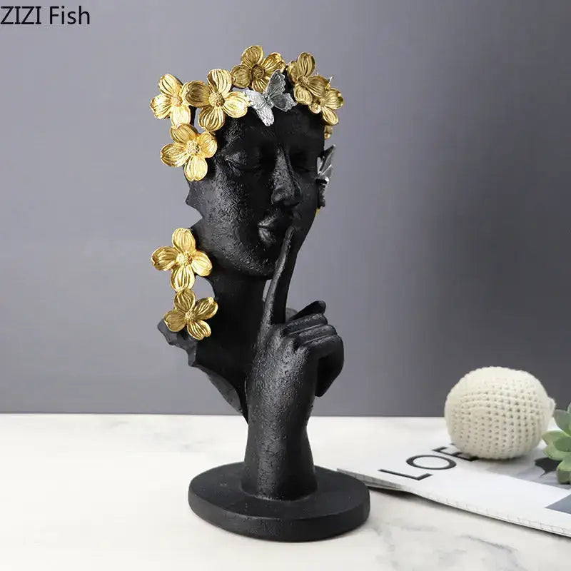 Black resin sculpture garland figure with golden flowers and silver butterflies making a shh gesture decorbites gold silence