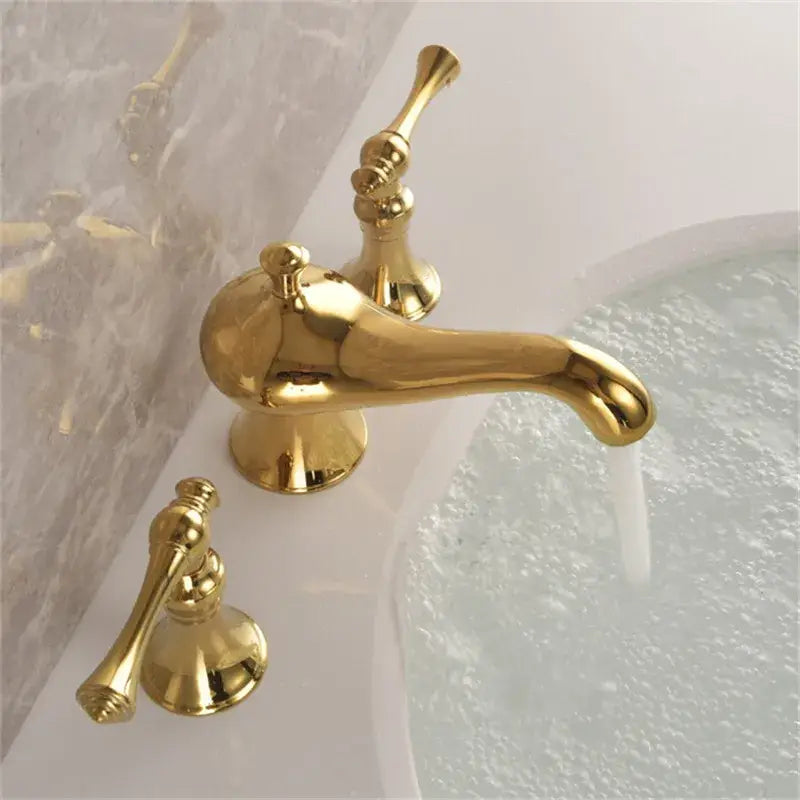 Gold widespread bathroom faucet with waterfall design featuring a gold-finished three-handle widespread bathroom faucet