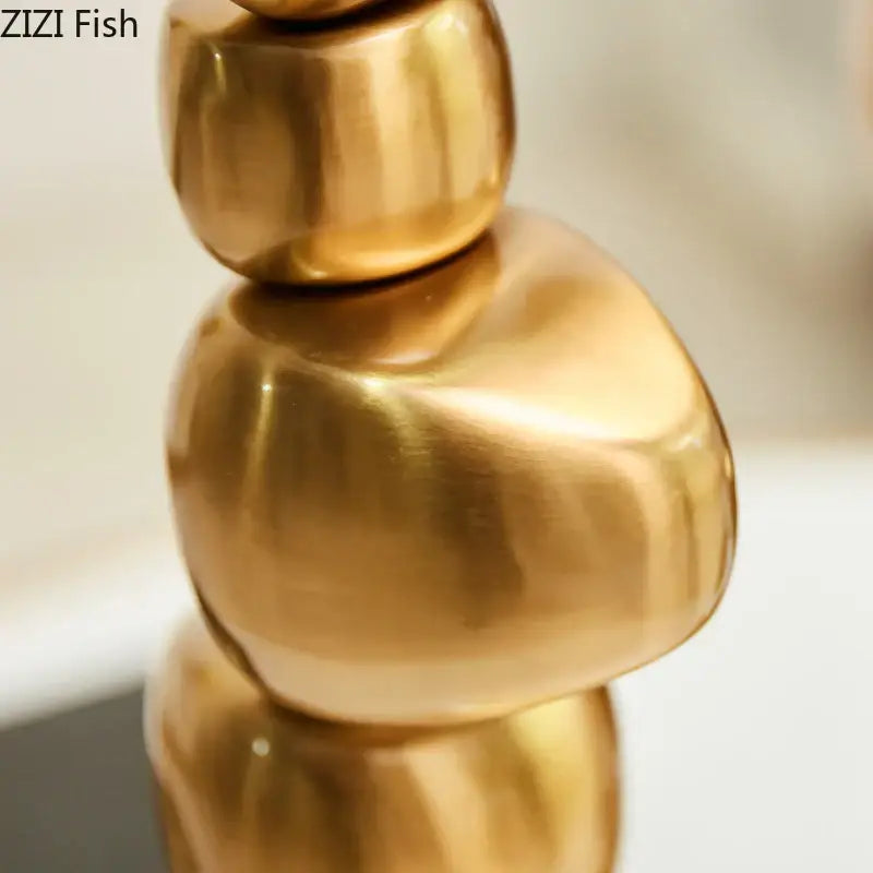 Golden alloy stone pile candle holder featuring polished stacked organic spheres for elegant living room decorbites golden alloy decor