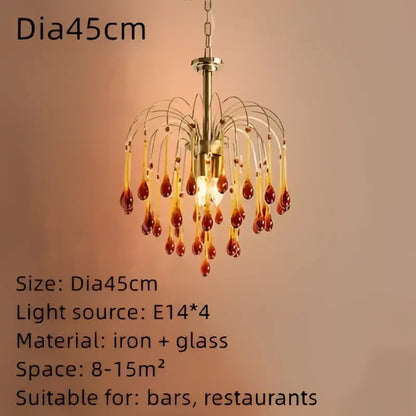 A brass-toned golden amber crystal water drop chandelier with dangling amber glass pendants for dining room lighting