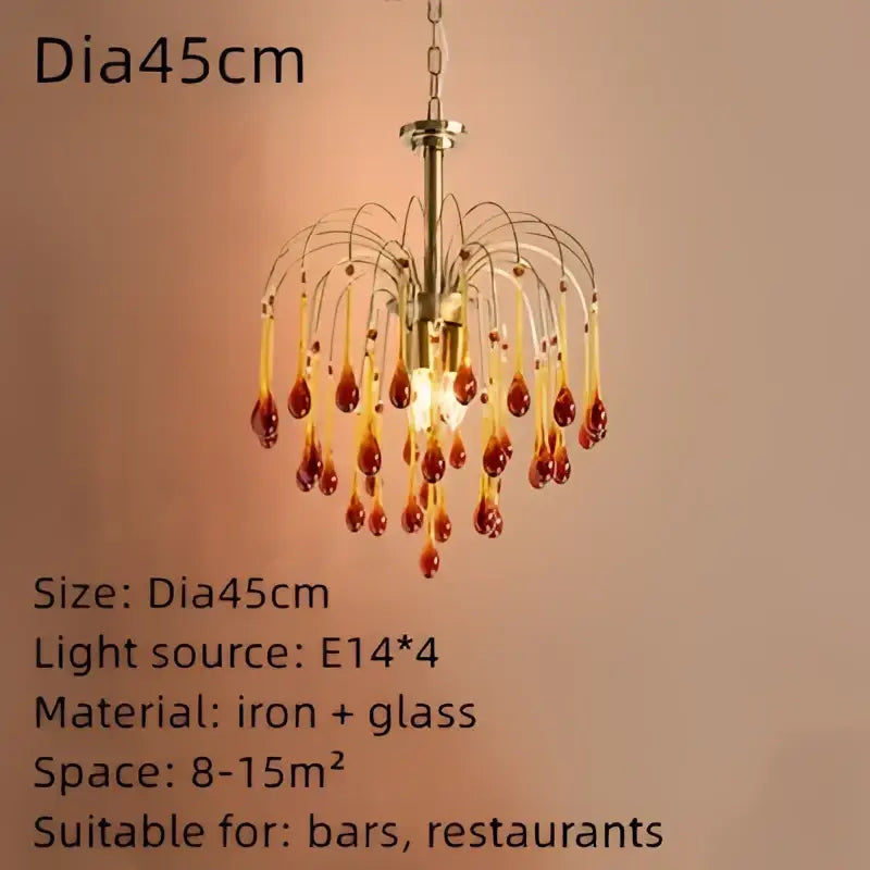 A brass-toned golden amber crystal water drop chandelier with dangling amber glass pendants for dining room lighting