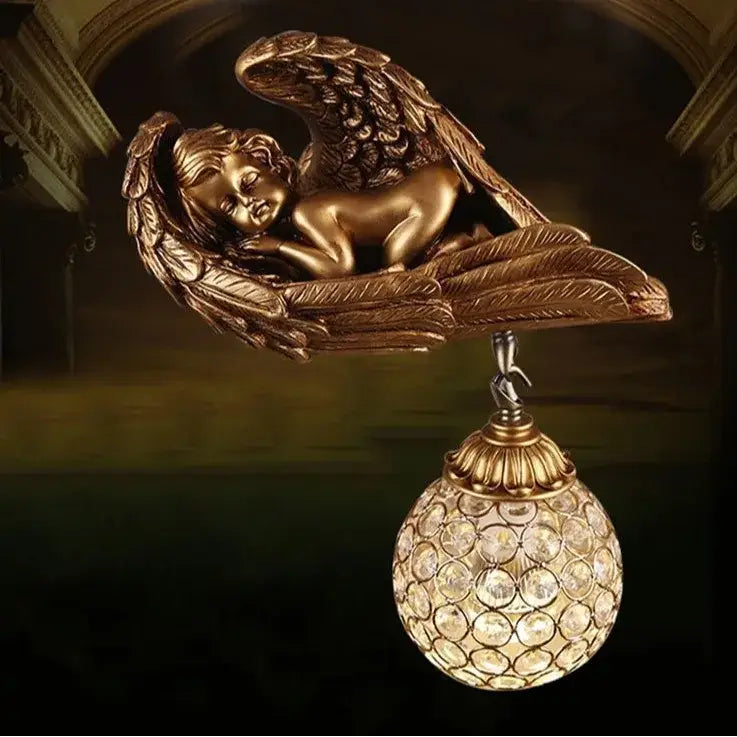 Golden angel wall lamp with intricate wing details and crystal globe lampshade for elegant living room decor