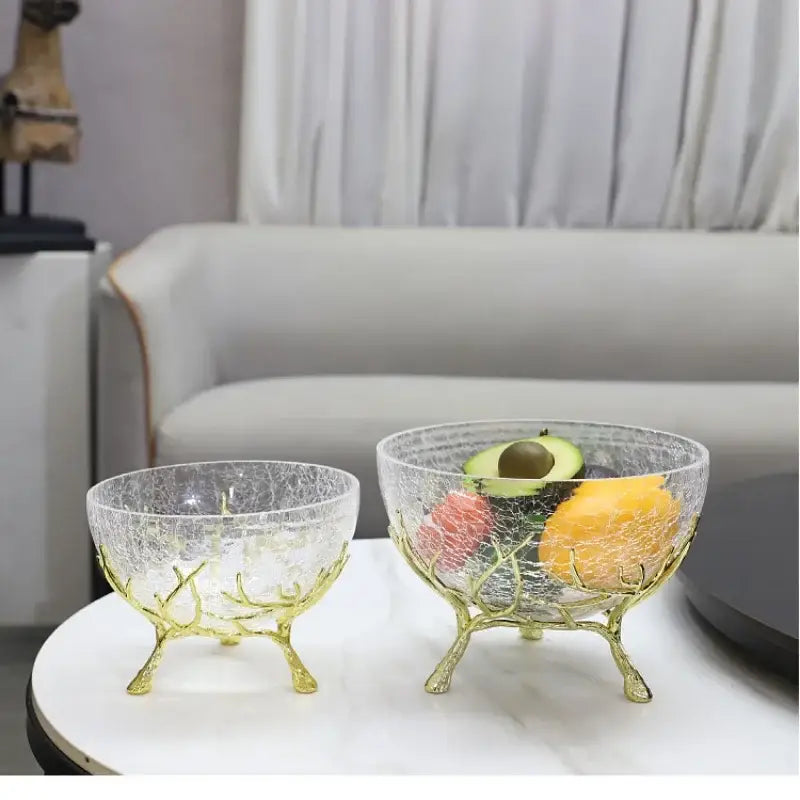 Clear glass fruit plate with crackled texture and gold metal tree branch stand as a dining room centerpiece bowl