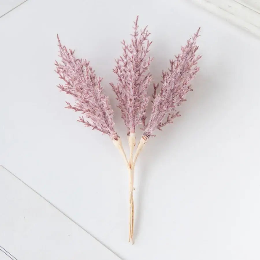 A delicate cluster of three faux grasses with soft pink plumes and beige stems in artificial autumn branches set decorbites decor