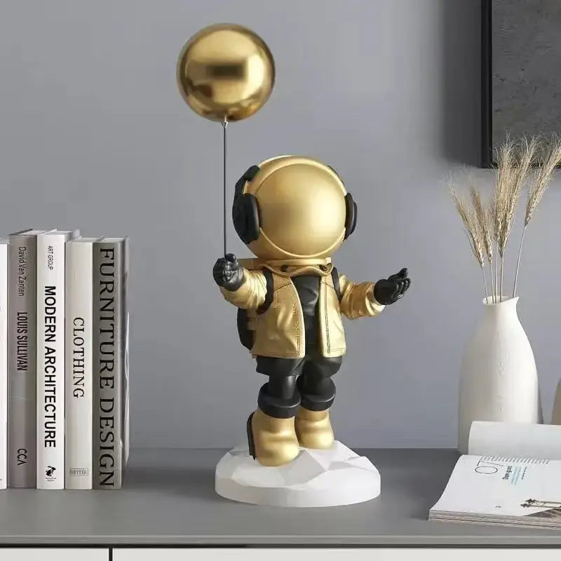 Golden astronaut resin home decor figurine with black accents holding a metallic gold balloon for living room display