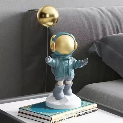 A teal and gold balloon astronaut resin figurine with headphones for resin home decor living room display