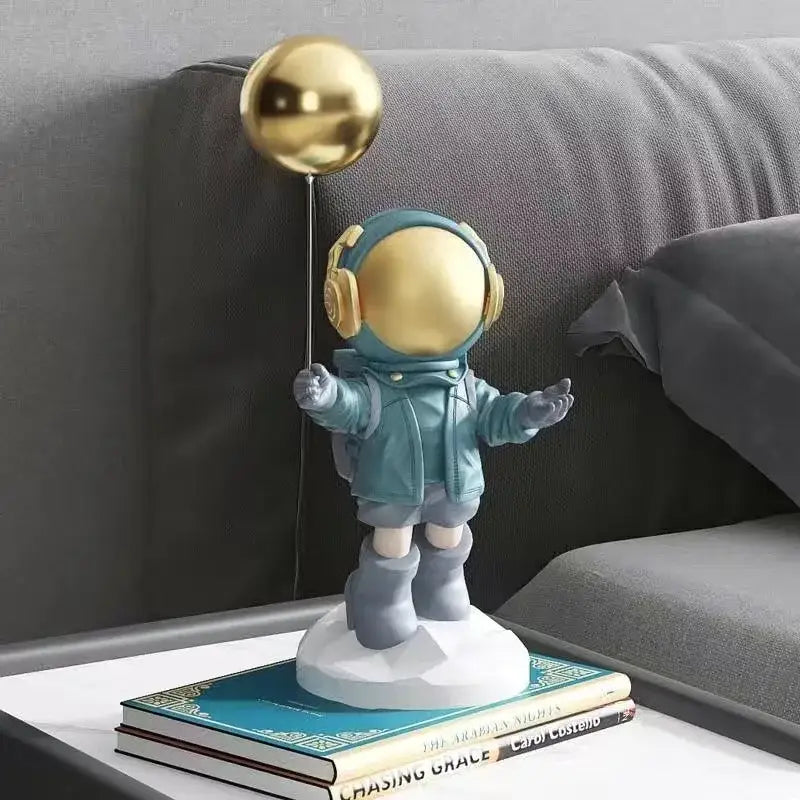 A teal and gold balloon astronaut resin figurine with headphones for resin home decor living room display