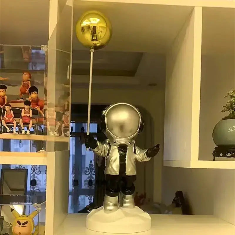 Silver resin astronaut home decor figurine holding a golden balloon stick for living room display