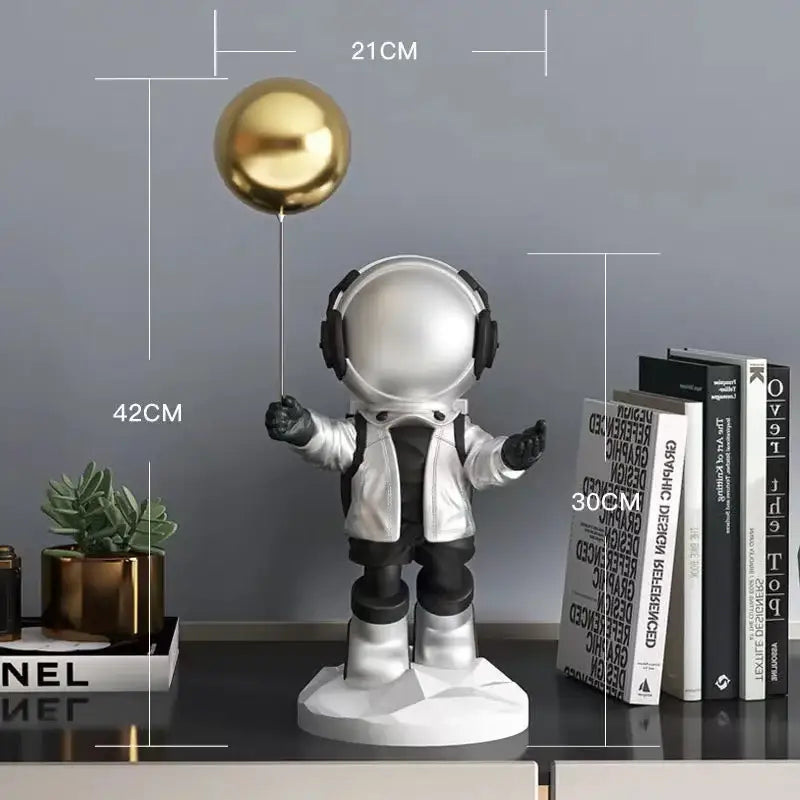 A sleek silver balloon astronaut resin figurine with black headphones holding a shiny gold balloon for resin home decor