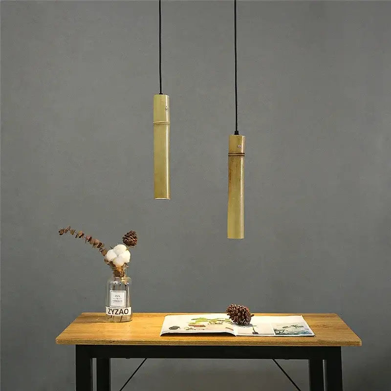 Two minimalist golden bamboo tube pendant lights with adjustable wire perfect for dining room pendant lights
