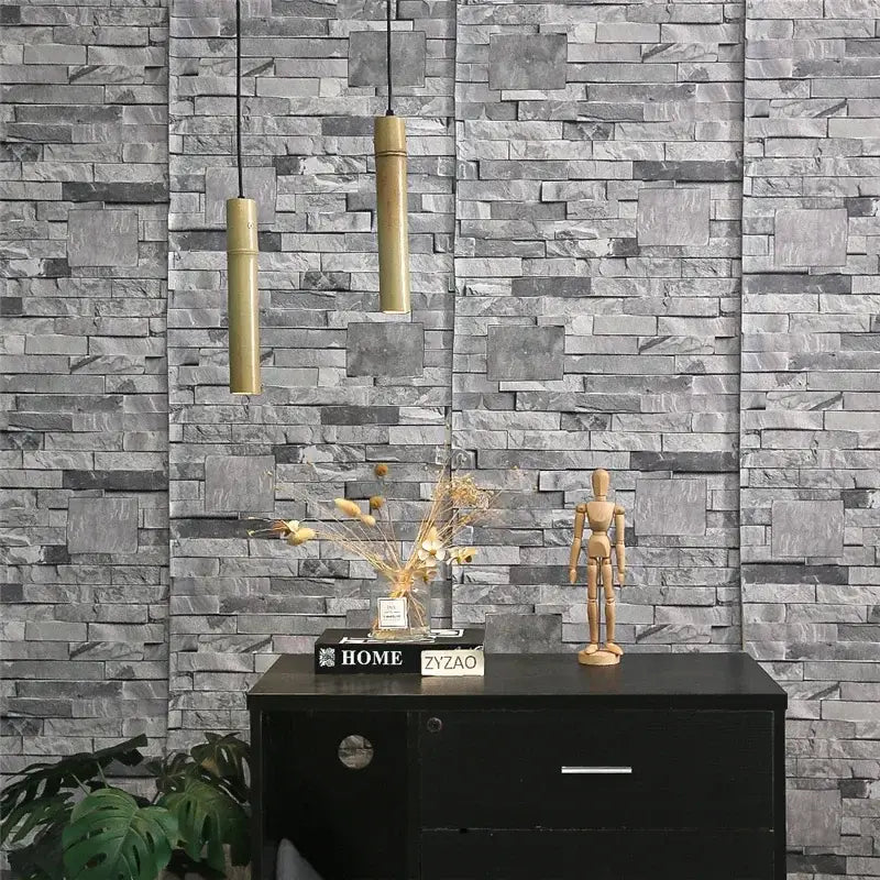 Two cylindrical gold-toned bamboo tube pendant lights with adjustable wire hanging over a dining room table