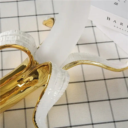 Glossy gold and white ceramic banana sculpture with peeled design as a decorbites glass lampshade night light