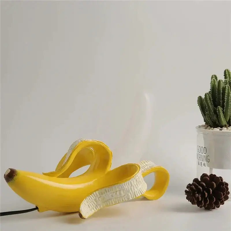A golden yellow glossy ceramic banana-shaped decorbites glass lampshade night light with peeled peel design and black cord