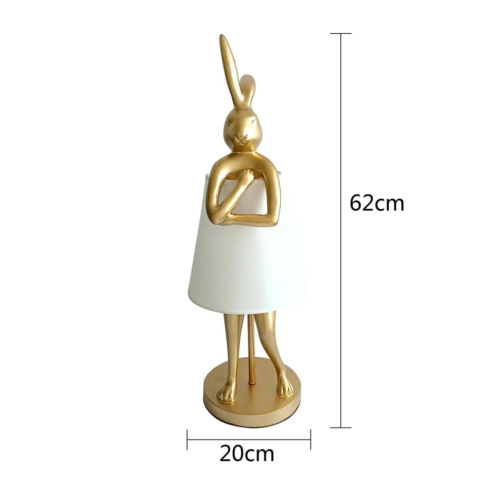 Golden bathing rabbit resin table lamp with a white lampshade dress on a circular base for bedroom decorbites decor