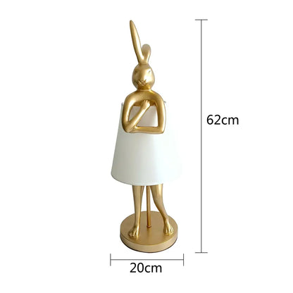 Golden bathing rabbit resin table lamp with a white lampshade dress on a circular base for bedroom decorbites decor