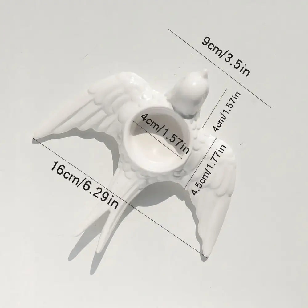 White ceramic bird-shaped candle holder tray with detailed wings and central circular opening for wedding decor