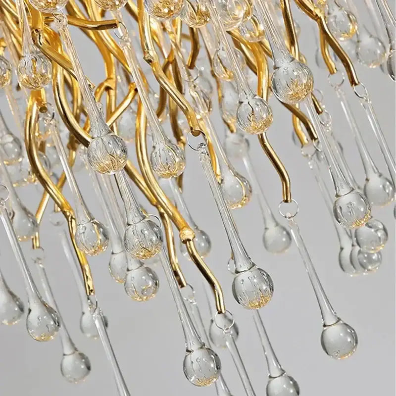 Elegant golden crystal chandelier with gold-toned metal and clear glass featuring teardrop crystal droplets for luxury lighting
