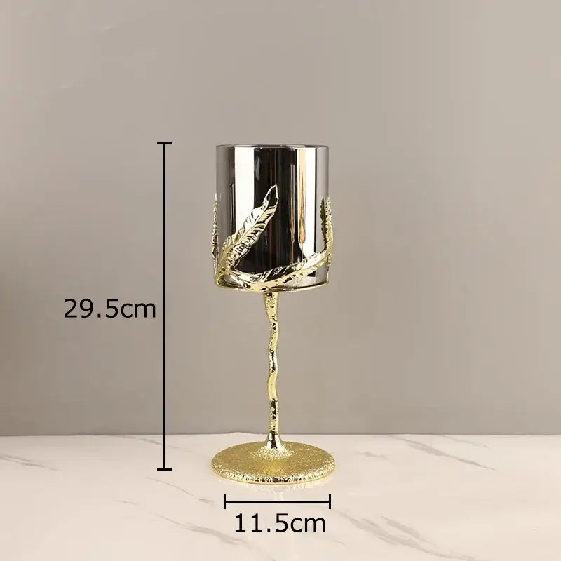 A gold-toned decorbites golden branches candle holder with silver cylinder and leaf embellishments for dining room decor