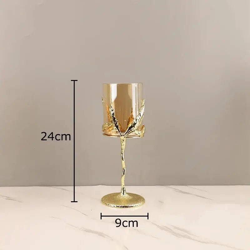 A tall slender gold-toned decorbites golden branches candle holder with twisted stem and leaf accents for dining room decor