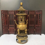 Golden brass three tiered tower incense burner with intricate carvings and elephant feet used as tripod furnace decor