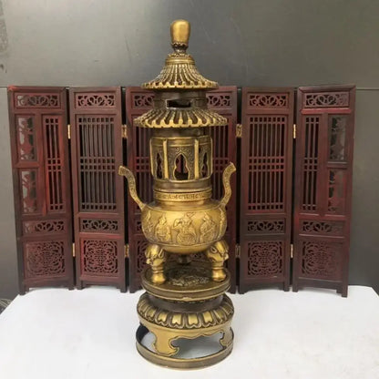 Golden brass three tiered tower incense burner with intricate carvings and elephant feet used as tripod furnace decor