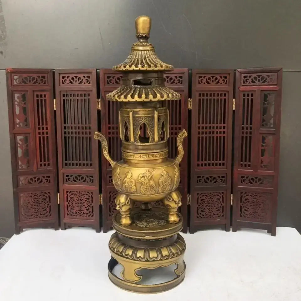 Golden brass three tiered tower incense burner with intricate carvings and elephant feet used as tripod furnace decor