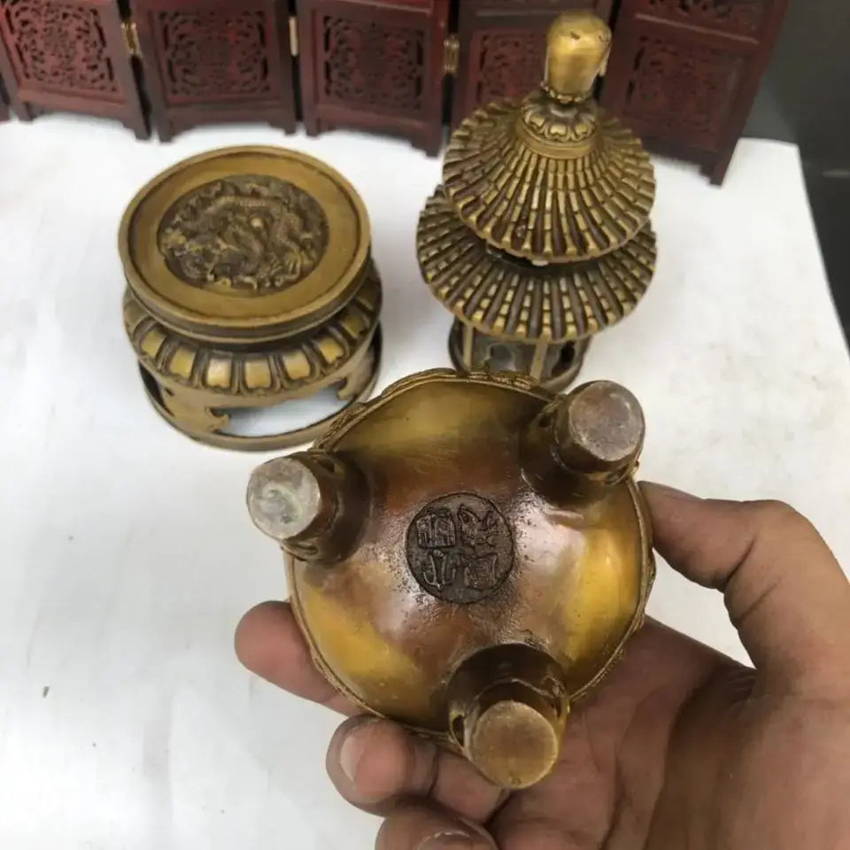 Golden brass tower incense burner with intricate carvings and three rounded feet tripod furnace for Buddhist hall decor