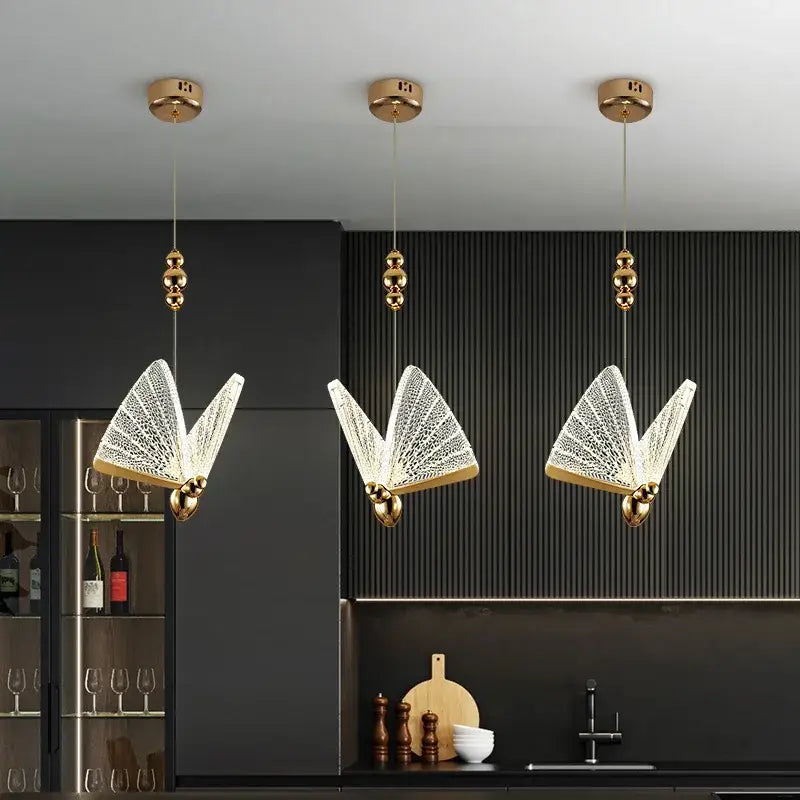 Three elegant gold-finished butterfly-shaped led pendant lights with intricate crystal mesh detailing for kitchens and dining rooms