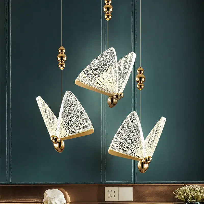 Three elegant gold-toned butterfly led pendant lights with intricate white lace glass wings for kitchen and dining room