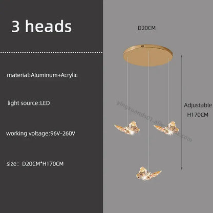 Gold-colored butterfly chandelier pendant light with three illuminated heads suspended from aluminum and acrylic mount