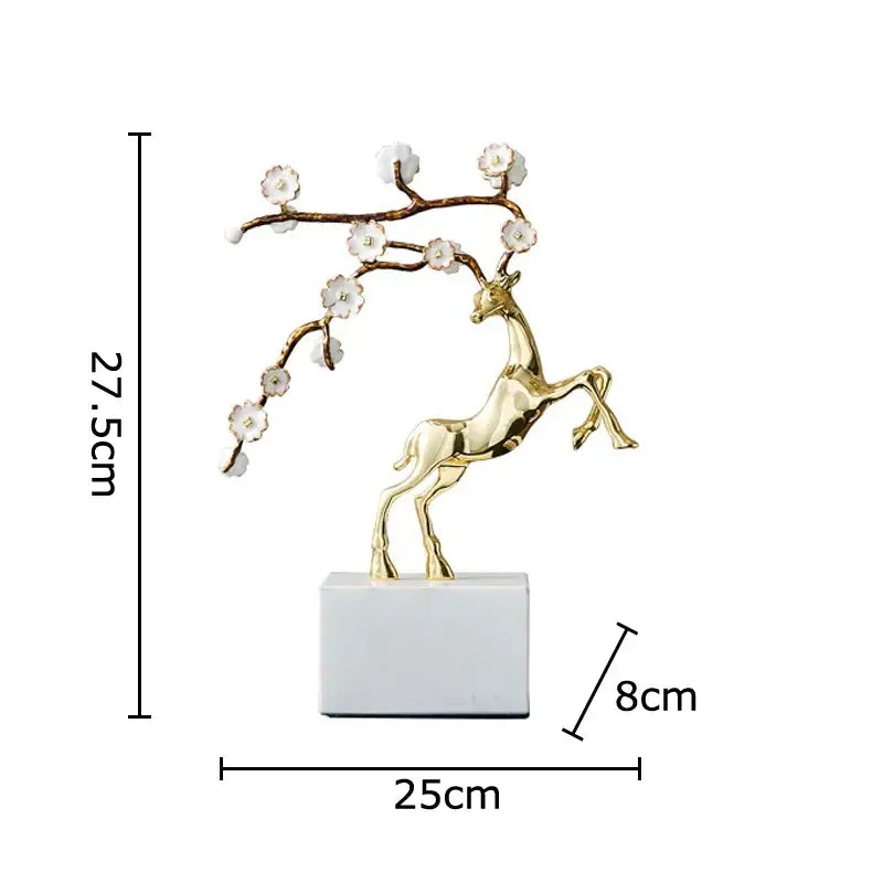 Golden deer antlers statue with delicate white blossoms on branching antlers on white marble base decorbites deer