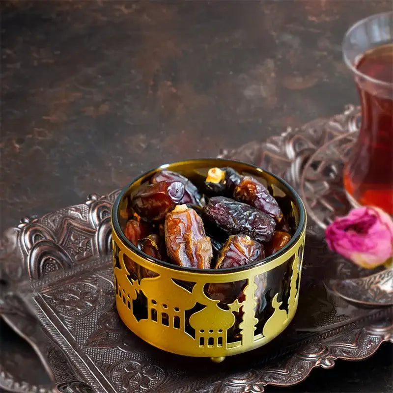 Golden eid mubarak metal snack tray with intricate mosque cutouts filled with dark brown dates for dining room use