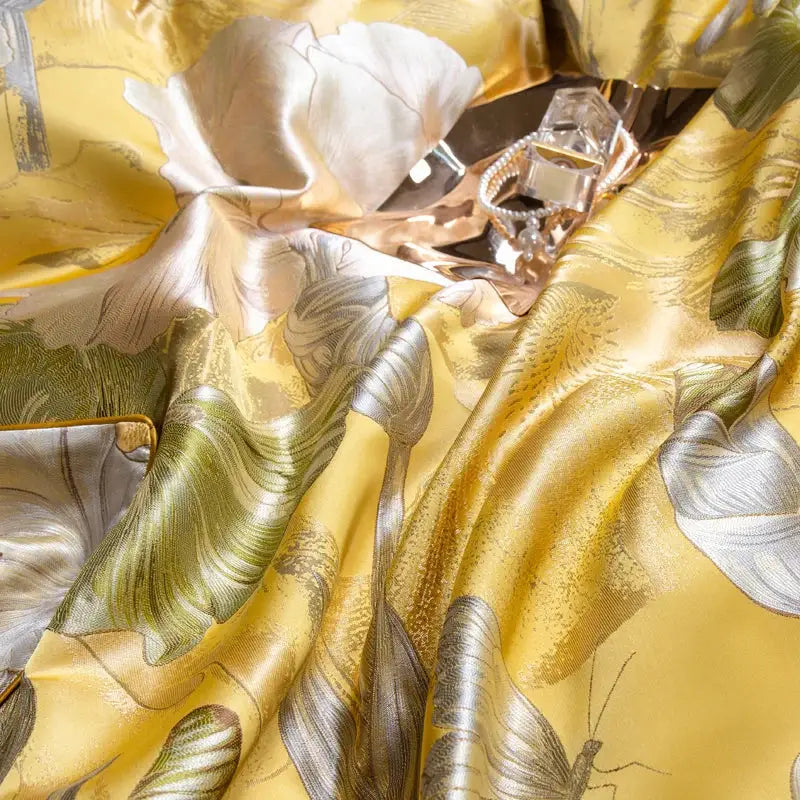 A luxurious golden-yellow silk scarf with silver and green floral butterfly motifs complements decorbites jacquard bedding set