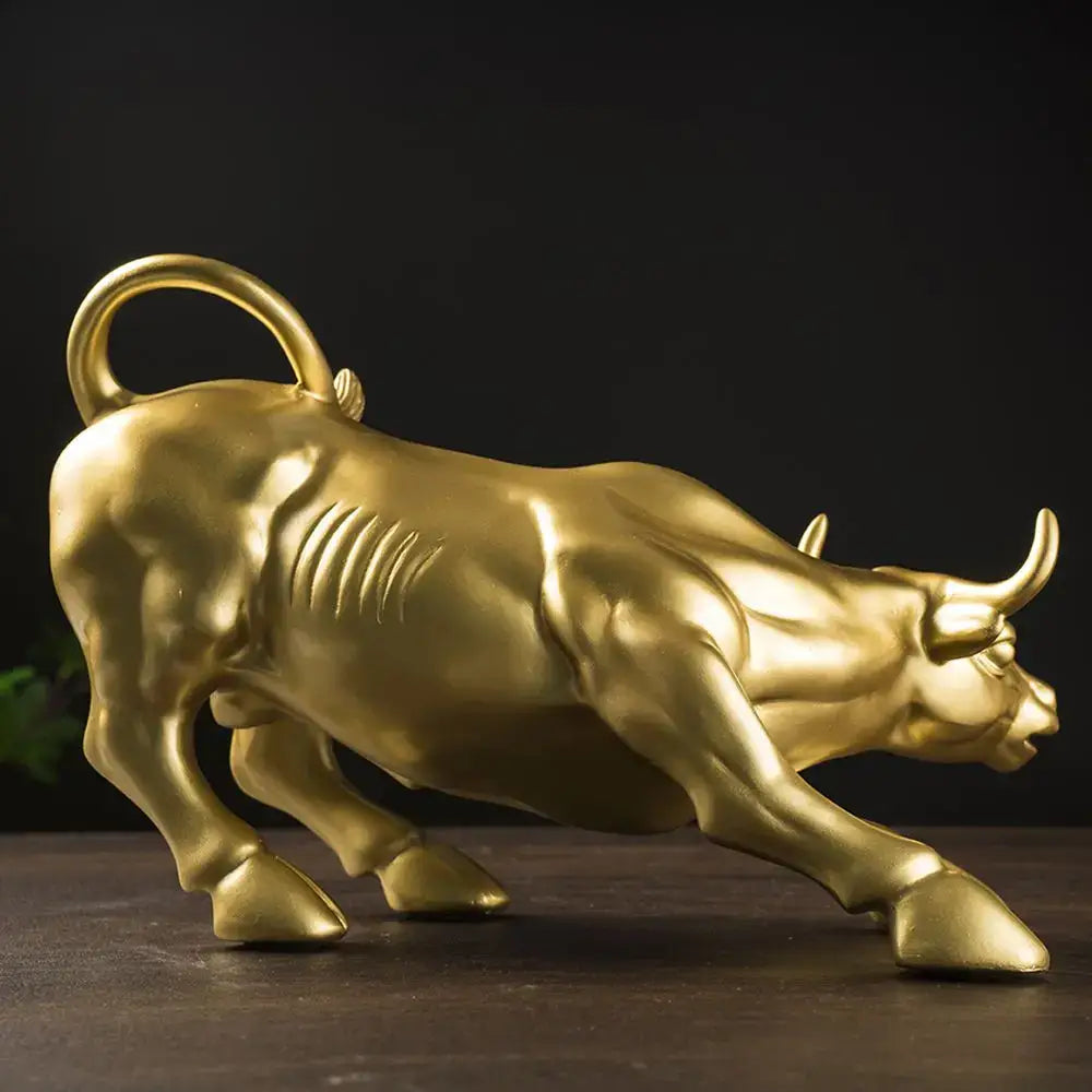 Golden metallic fortune resin sculpture bull with looped tail in dynamic charging pose for office desk decor