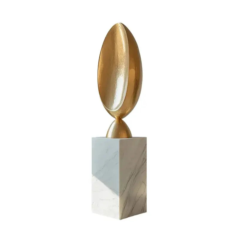 Golden geometric tree hole sculpture with golden metallic egg shape mounted on white marble pedestal decorbites golden geometric
