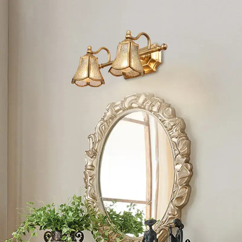 Gold-toned wall-mounted sconce with two textured bell-shaped glass shades for decorbites golden glass mirror cabinet light