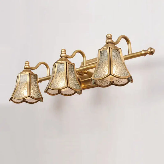 Gold-toned three-light vanitiy fixture with textured translucent glass shades for decorbites golden glass mirror cabinet light