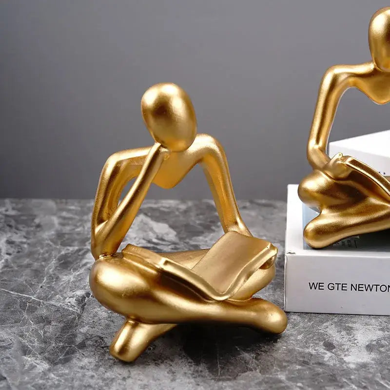 Golden glossy abstract thinker resin figurine of a seated thinker holding an open book for office decorbites decor